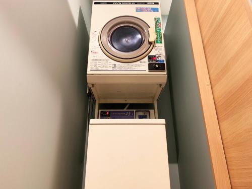 a washing machine is sitting on top of a refrigerator at Cactus Inn / Vacation STAY 51554 in Miyazaki