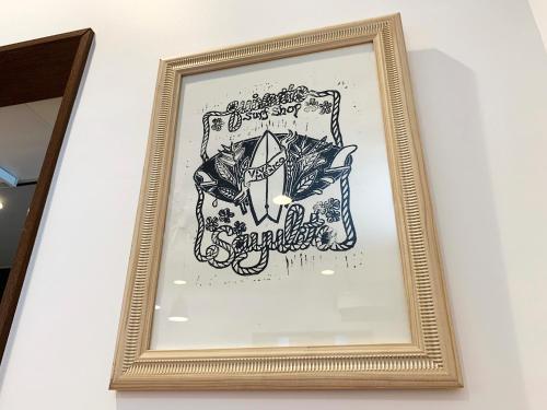 a picture of a drawing in a gold frame on a wall at Cactus Inn / Vacation STAY 51554 in Miyazaki