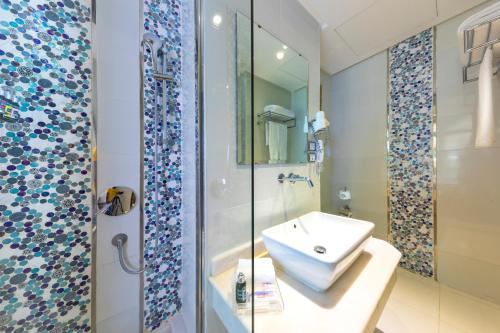 a bathroom with a sink, mirror, and bathtub at Al Masa Hotel Nasr City in Cairo