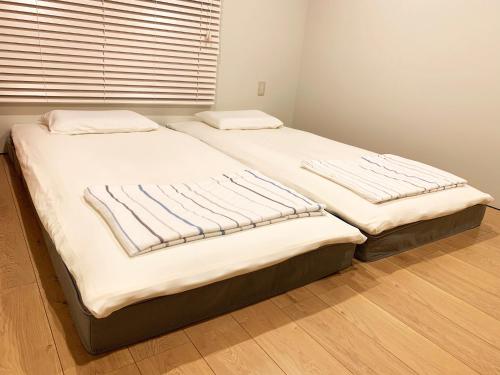 2 nebeneinander sitzende Betten in einem Schlafzimmer in der Unterkunft Cactus Inn / Vacation STAY 51547 in Miyazaki