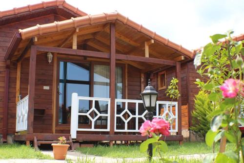 a wooden house with a porch and a balcony at Villa Efsane Hotel in Cıralı