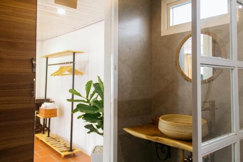 a bathroom with a mirror and a wooden shelf at Dalat 1893 Homestay in Da Lat