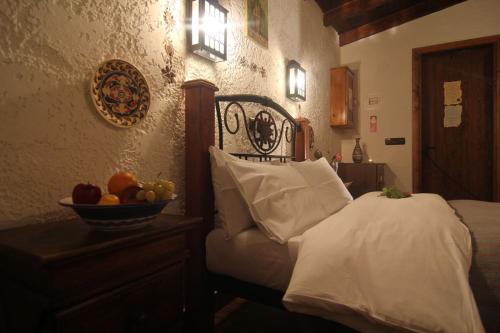 a bedroom with a bed with a bowl of fruit on a table at Chateaux Constantin Agistro in Ángistron