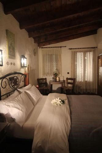 a bedroom with a bed and a table with flowers on it at Chateaux Constantin Agistro in Ángistron
