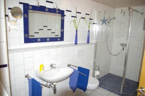 a bathroom with a sink and a shower and a toilet at Ferienwohnung Am Erlenhof in Gleiszellen-Gleishorbach