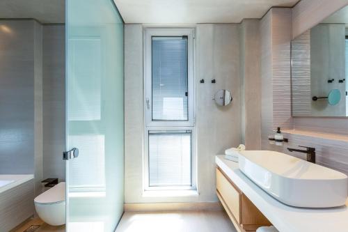 a white bathroom with a sink and a toilet at Sissy Luxury Villa Chania in Plataniás