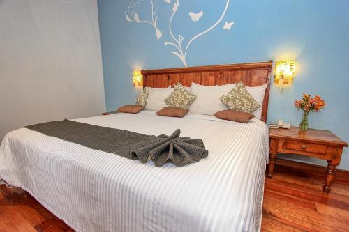 a bedroom with a white bed with a bow on it at Hotel San Marcos in San Cristóbal de Las Casas