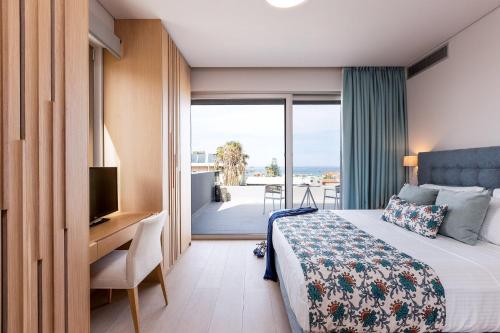 - une chambre avec un lit et un bureau avec une télévision dans l'établissement Sissy Luxury Villa Chania, à Platanias