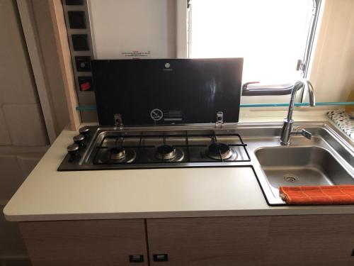 a kitchen counter with a stove and a sink at Caravans through the nature in Mikhmoret