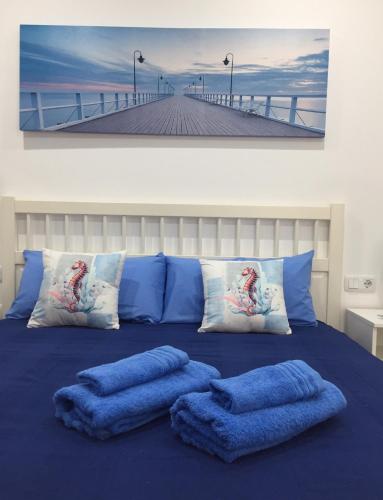 a bedroom with blue pillows on a bed with a pier at Casa Alejandro II in Tarajalejo