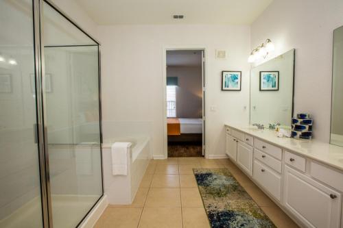 La salle de bains est pourvue d'une douche et d'un lavabo. dans l'établissement Vista Cay Luxury 4 bedroom condo (#3117), à Orlando