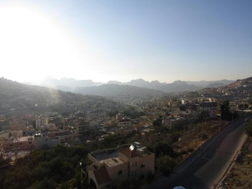 a view of a city with a road and mountains at Petra Monastery Tourist Hotel in Wadi Musa