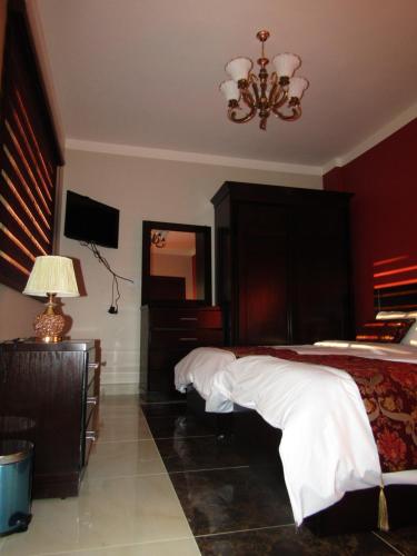 a bedroom with a bed and a chandelier at Petra Monastery Tourist Hotel in Wadi Musa