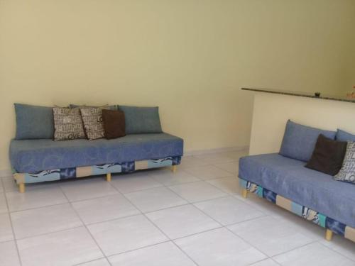a living room with two blue couches in a room at Linda casa ! in Mongaguá