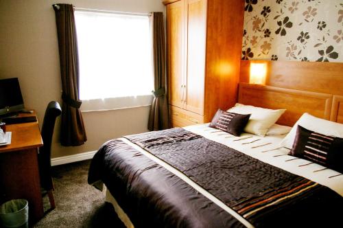 a bedroom with a large bed with a window at Trivelles Park Hotel in Preston