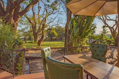 a wooden table and chairs with an umbrella at Heritage by Serendib in Blantyre