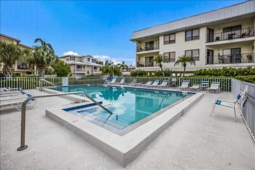 a swimming pool in front of a building at Gulf Watch 204 Condo in Bradenton Beach