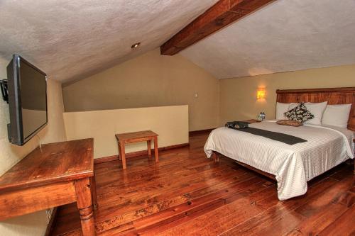 a bedroom with a bed and a flat screen tv at Hotel San Marcos in San Cristóbal de Las Casas