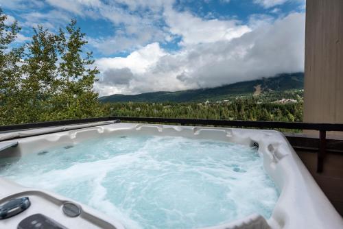 a jacuzzi tub with a view of the mountains at The Ironwood on Blueberry Hill in Whistler
