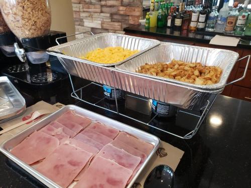 a counter with two trays of food on a stove at Arecibo Inn in Arecibo