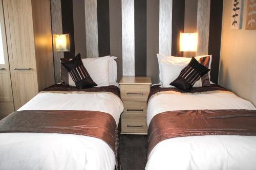 two beds sitting next to each other in a room at Trivelles Park Hotel in Preston