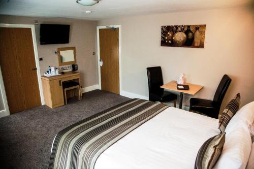 a hotel room with a bed and a desk at Trivelles Park Hotel in Preston