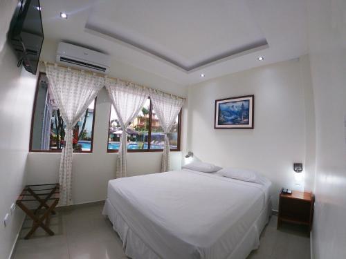 ein Schlafzimmer mit einem weißen Bett und einem Fenster in der Unterkunft Siona Hotel in Atacames