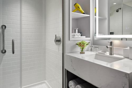 a white bathroom with a sink and a shower at Hyatt Centric Old Town Alexandria in Alexandria