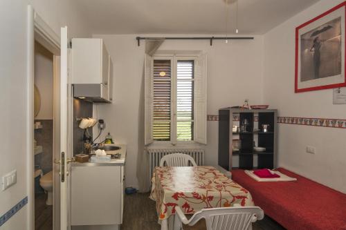 a small room with a table and a kitchen at Le Ciel d'Orphèe in Pisa