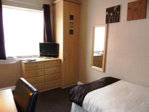 1 dormitorio con 1 cama y vestidor con espejo en Trivelles Park Hotel, en Preston