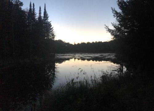 a view of a river with the sun setting at Chalet Mont Tremblant Luxury Lodge in Labelle