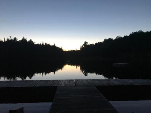 a view of a lake with the sun setting at Chalet Mont Tremblant Luxury Lodge in Labelle