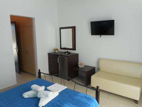 a bedroom with a bed and a couch and a television at Anatoli in Agia Pelagia Kythira