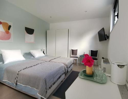 um quarto branco com uma cama e uma mesa em Nana / Sobe & Apartmani em Valjevo