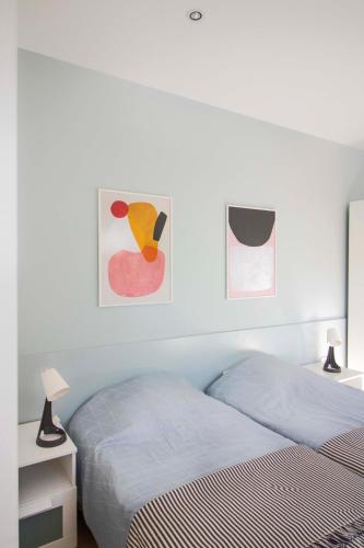 a bedroom with two beds and two paintings on the wall at Nana / Sobe & Apartmani in Valjevo
