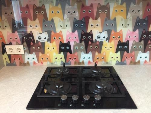 un groupe de chats sur un mur derrière un poêle dans l'établissement Cat Garden Premium Apartments Riga, à Riga