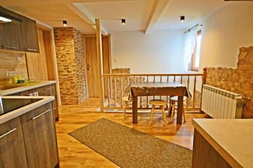 a kitchen with a table and a dining room at Pokoje gościnne Pod Limbami in Male Ciche