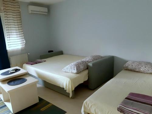 um quarto com duas camas e uma mesa em MIMOZA 1 em Jagodina