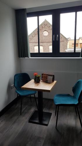 a table and two chairs in a room with two windows at B&B La Vita Verde in Susteren