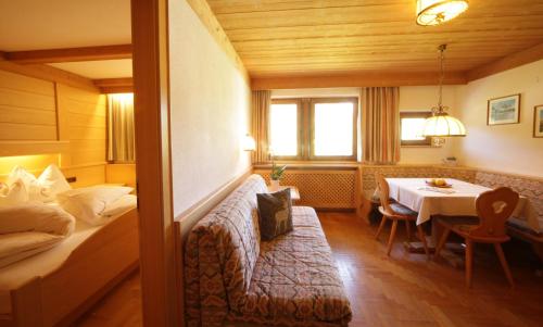 a hotel room with a bed and a table at Residence Belavista in Corvara in Badia