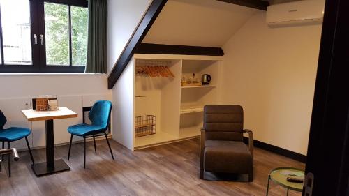 a waiting room with a table and chairs at B&B La Vita Verde in Susteren