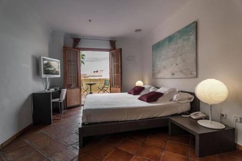 1 dormitorio con 1 cama y 1 mesa con lámpara en Hotel Nou Roma, en Denia