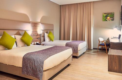 een hotelkamer met 2 bedden en een bureau bij Hotel F25 in Ibagué