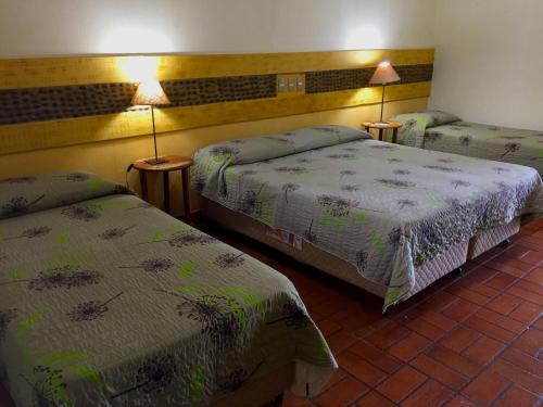 a hotel room with two beds and two lamps at Fazenda San Francisco in Pôrto