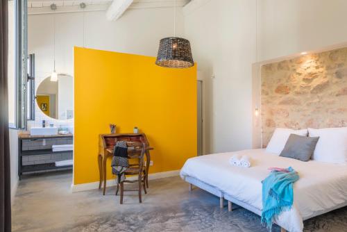 a bedroom with a bed and a yellow wall at Domaine la Clausade in Mauguio