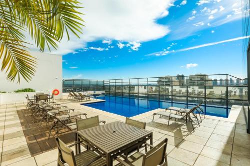 a patio with tables and chairs and a swimming pool at TRYP By Wyndham Ribeirão Preto in Ribeirão Preto