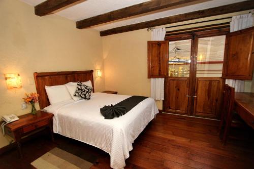 a bedroom with a white bed and a window at Hotel San Marcos in San Cristóbal de Las Casas