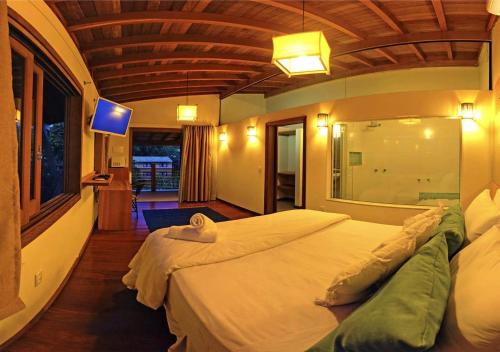 a bedroom with a large bed in a room at Pousada Paraíso Gaia in Praia do Rosa