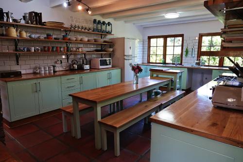 - une cuisine avec une table en bois et des bancs dans l'établissement Trengwainton House, à Hogsback