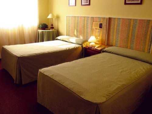 a hotel room with two beds and a window at Hotel Casablanca Vigo in Vigo